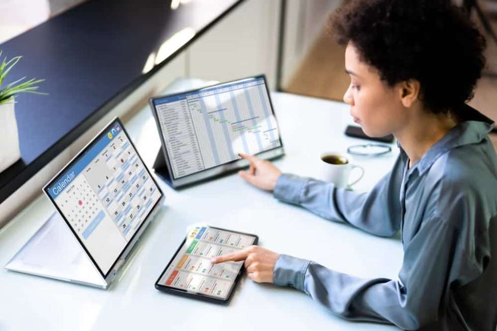 a woman working on two different computers 