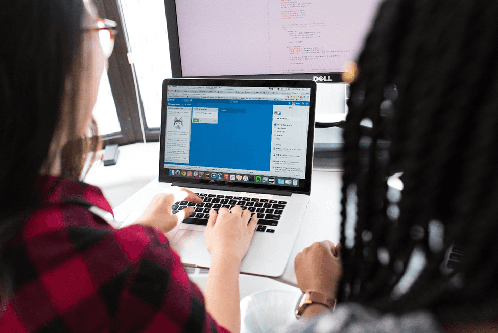 stock image of two people working on a computer 