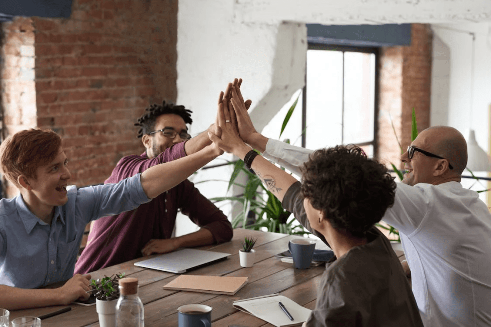 stock image of a group of people giving the five high 