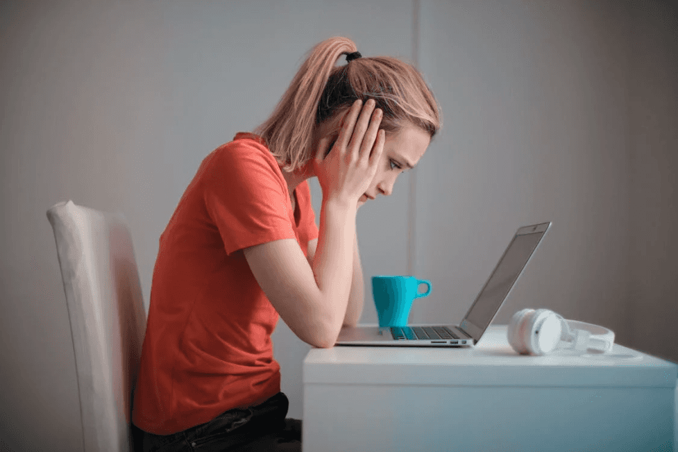 stock image of a woman worried looking at a computer 