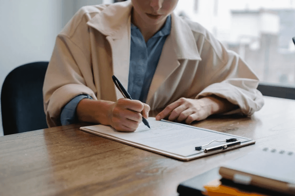 stock image of a woman signing a document 